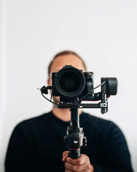 Auto-portrait d'un photographe avec sa caméra en premier plan